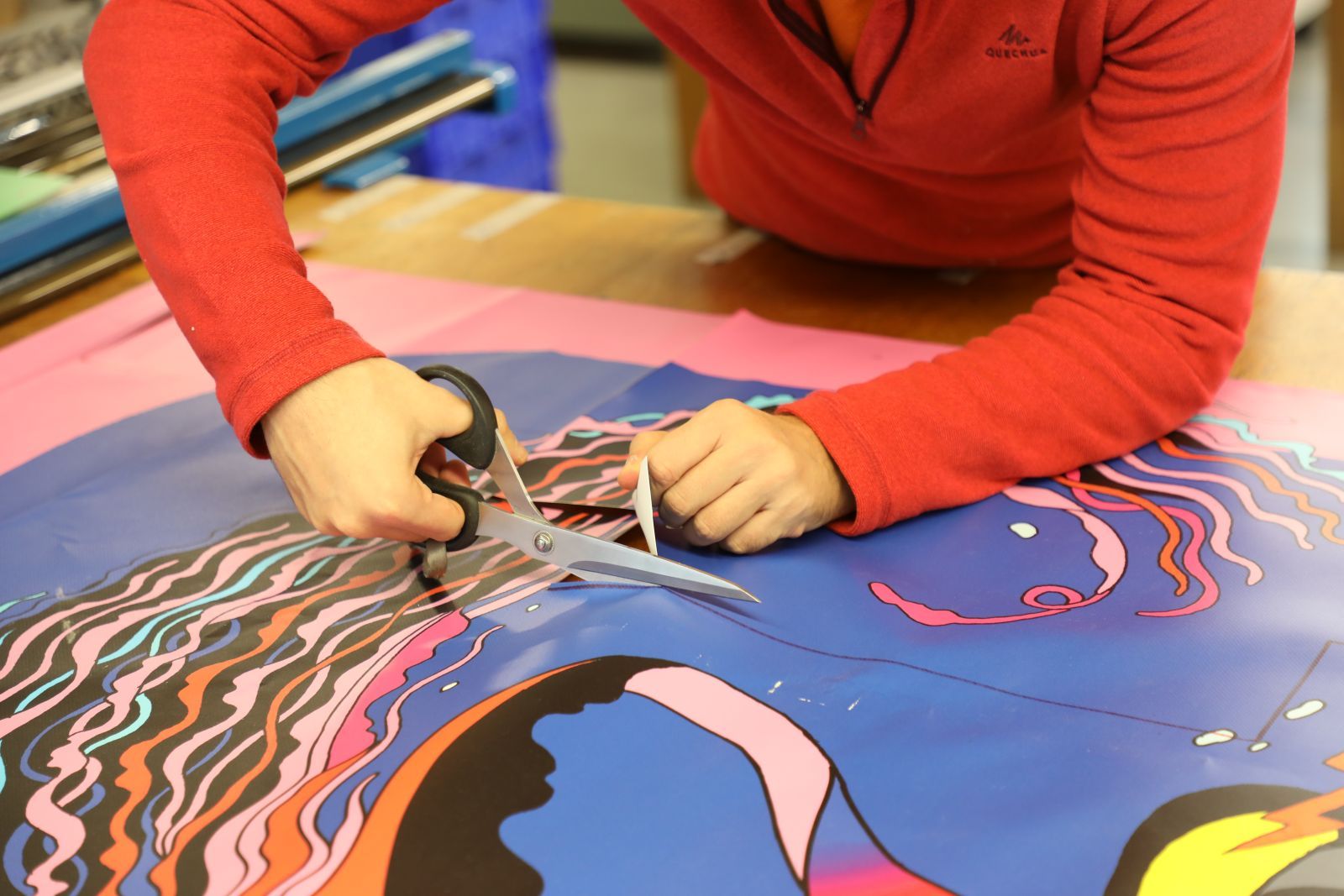 Jeremy, travailleur à l'ESAT, s'attèle à la découpe des patrons